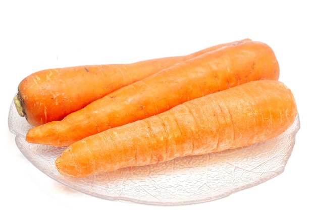 marchewki na talerzu na białym tle
