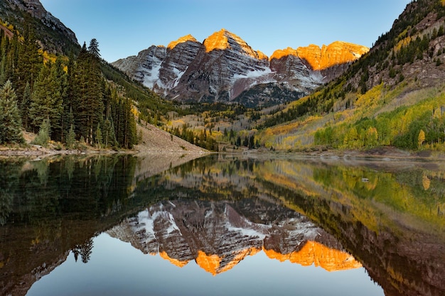 Maroon Bells otoczeni jeziorem pod słońcem w Kolorado w USA