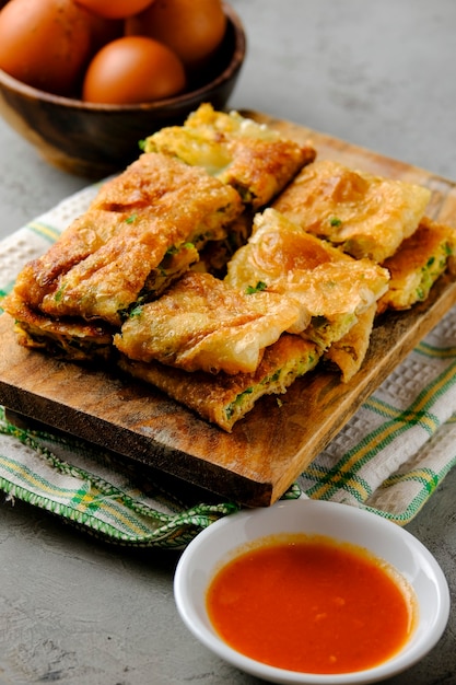 Martabak Telor lub Martabak Telur. Pikantne ciasto smażone na patelni nadziewane jajkiem, mięsem i przyprawami. Martabak Telur to jedna z indonezyjskich ulicznych potraw