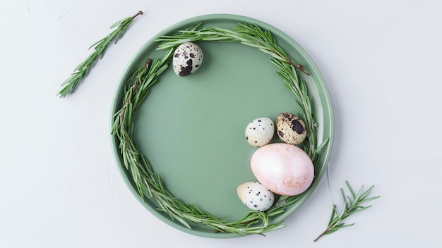Zdjęcie martwa natura wielkanocna, malowane kolorowe jajka i jajka przepiórcze leżące w misce na szarym tle