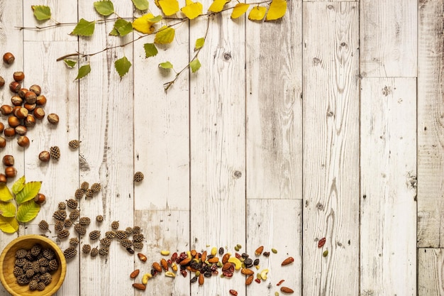 Zdjęcie martwa natura z opadłymi jesiennymi liśćmi i orzechami na drewnianym garnku