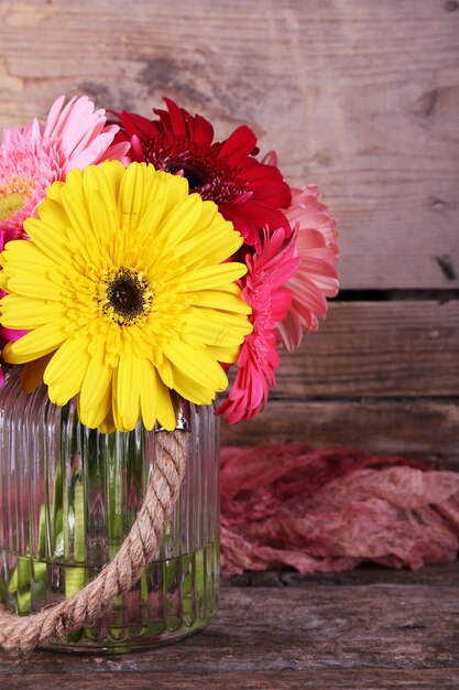 Zdjęcie martwa natura z pięknymi jasnymi kwiatami gerbera na drewnianym tle