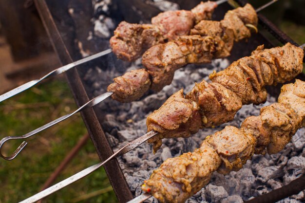 Zdjęcie marynowane mięso na metalowych szaszłykach gotowane na grillu na świeżym powietrzu