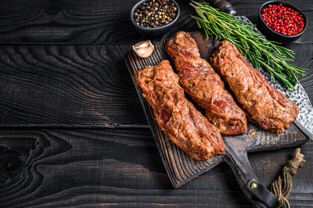 Marynowane Steki Z Mostka W Sosie Bbq Na Drewnianej Desce Do Krojenia Z Ziołami Na Drewnianym Stole. Widok Z Góry.