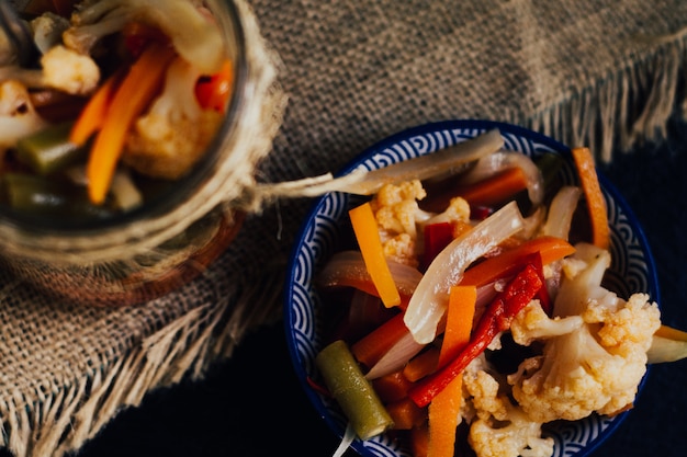 Zdjęcie marynowane warzywa, ocet, marchew, cebula, kalafior, strąki i słodka papryka.