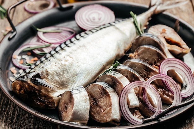 Zdjęcie marynowany filet z makreli z pokrojoną cebulą podawany na metalowej tacy. tło przepis żywności. ścieśniać.