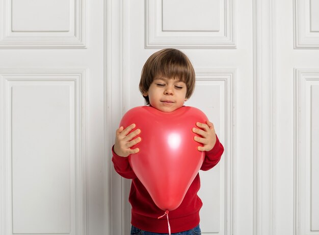 Marzycielski Chłopiec Trzymając Serce Czerwony Balon Na Białym Tle