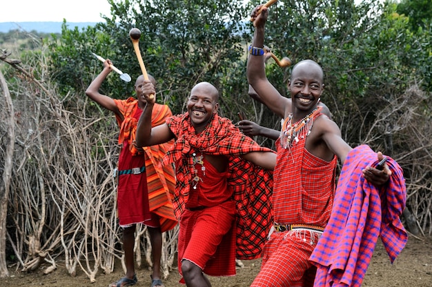 Masai Mara, Kenia - 13 sierpnia: wojownicy Masajów tańczą tradycyjne skoki jako ceremonia kulturalna. A także kobiety śpiewają i tańczą. Park Narodowy Masai Mara, 13 sierpnia 2015 w Kenii