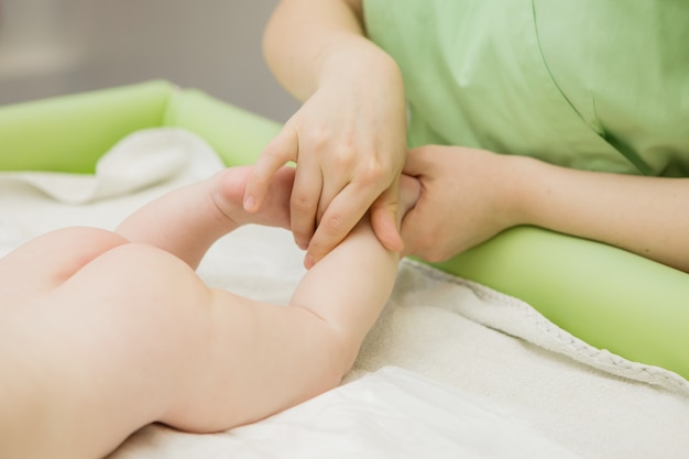 masaż dla dzieci, lekarz masujący lub robiący gimnastykę niemowlę
