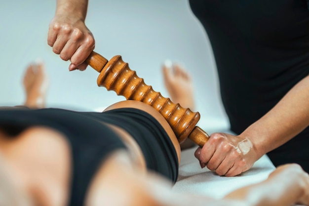 Zdjęcie masaż terapii rolling pin madero masażystka wykonująca leczenie redukcji cellulitu