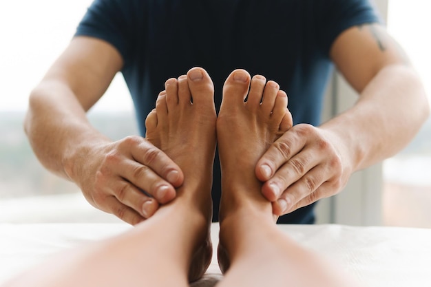 Masażysta podczas kobiecego masażu stóp