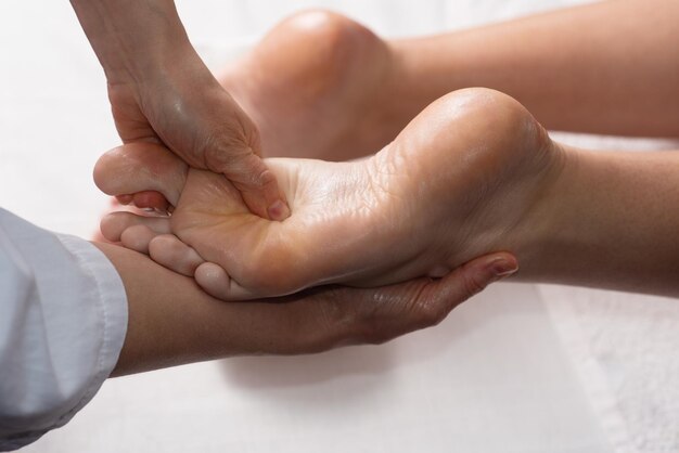Masażysta robi masaż stóp olejem w salonie spa Procedury Spa Koncepcja pielęgnacji ciała Widok zbliżenie