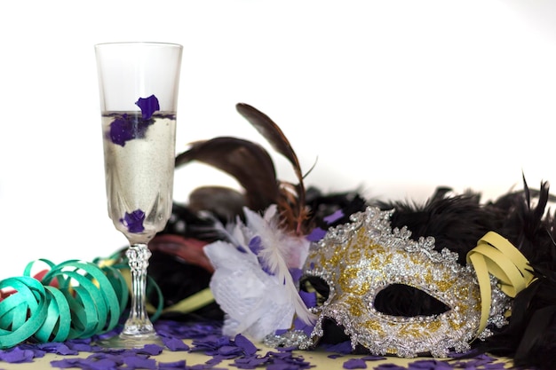 Zdjęcie maska karnawałowa, kieliszek szampana i konfetti.
