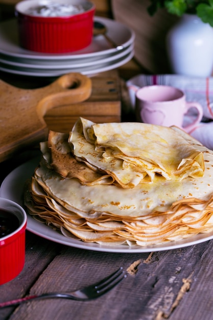 Maslenitsa i tydzień naleśników. danie pełne rosyjskich tradycyjnych naleśników z kwaśną śmietaną na spodku