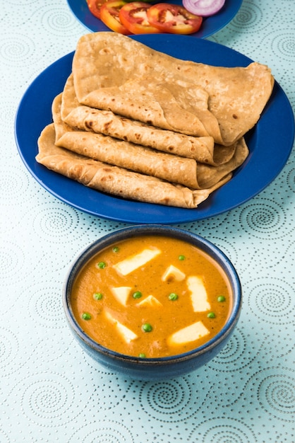 Masło Paneer Masala to słynny indyjski przepis na jedzenie przyrządzane z twarogu, podawane z płaskim chlebem znanym również jako roti lub chapati. selektywne skupienie