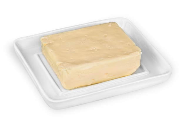 Masło w całości na białym talerzu na białym tle