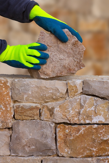 Mason rąk do pracy na murze kamiennym murem