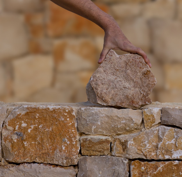 Mason rąk do pracy na murze kamiennym murem