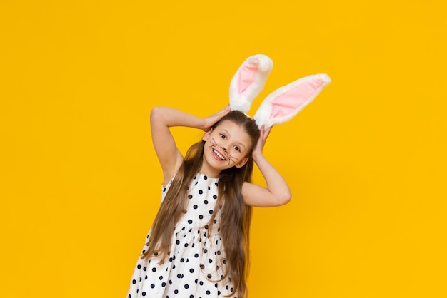 Masquerade Easter bunny uszy na pi?knej ma?ej dziewczynki na ?ó?tym tle odizolowane Dziewczyna z twarzą Zajączek