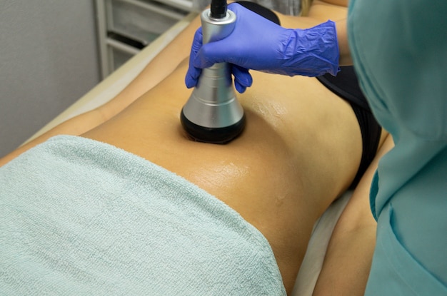 Master Beauty Center przeprowadza procedurę odchudzania za pomocą specjalnego urządzenia