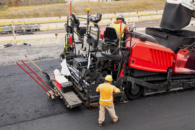 Maszyna do układania asfaltu i parowy walec drogowy podczas prac drogowych i remontowych