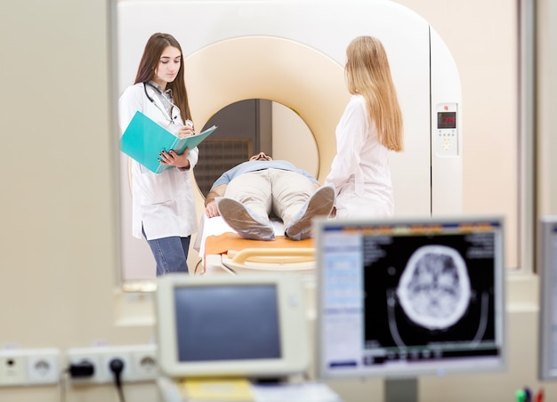 Maszyna MRI i ekrany z lekarzem i pielęgniarką