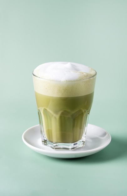 Matcha zielona herbata latte w szklance t na zielonym tle Zdrowy napój Vertical