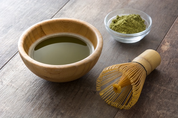 Matcha zielona herbata w misce i bambusowa trzepaczka do drewna