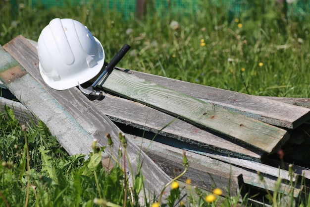 Materiały budowlane leżą na młotku do trawy i kasku