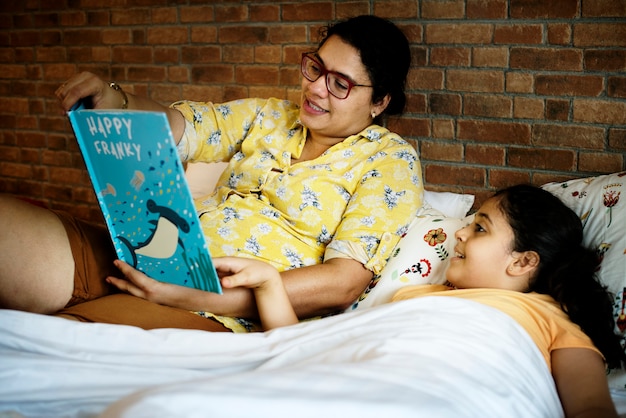 Zdjęcie matka czytając historię łóżka dla swojej córki