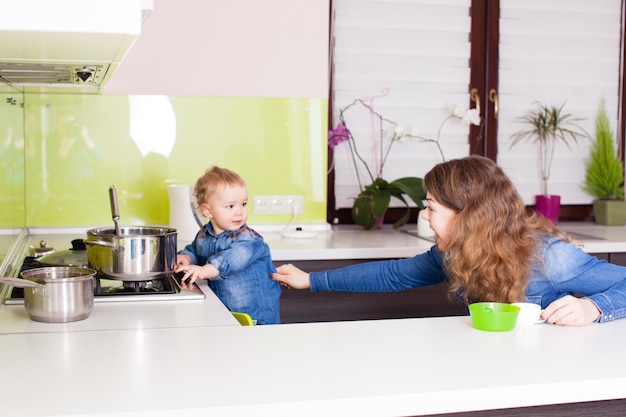 Zdjęcie matka dba o bezpieczeństwo syna w pobliżu kuchenki gazowej w kuchni, koncepcja