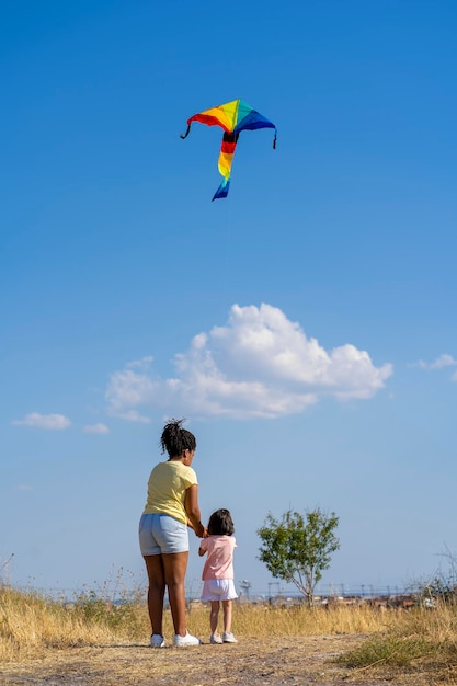 Matka i córka bawią się latawcem w terenie