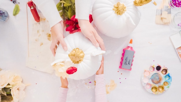 Matka i córka dekorują dynie rzemieślnicze z motywem jednorożca na Halloween.