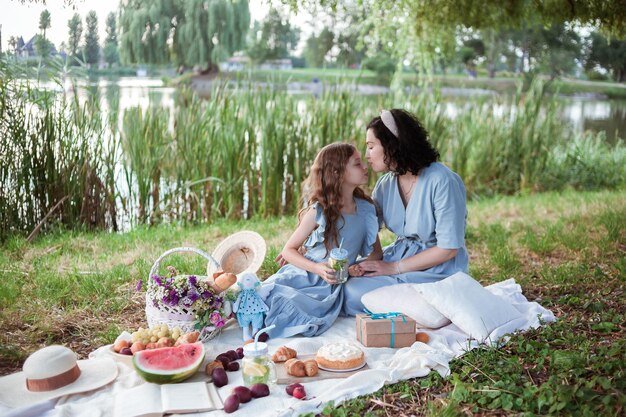 Matka i córka na pikniku w parku nad brzegiem rzeki