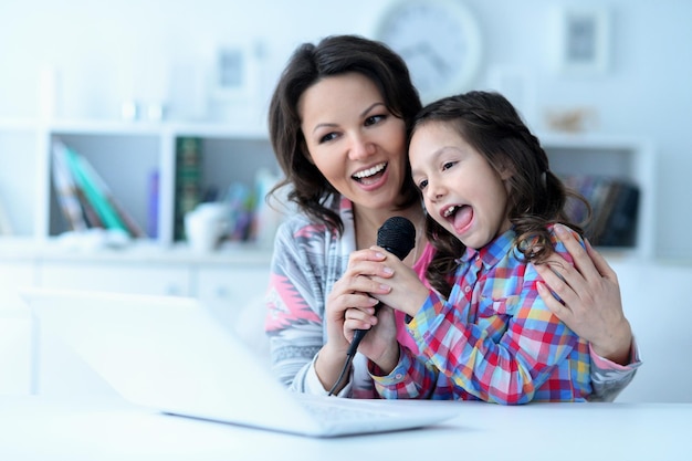 Matka i córka razem śpiewają przy laptopie