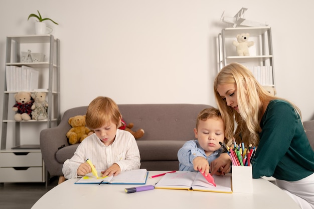 Matka i dwójka synów razem rysują farbę, mama pomaga dzieciom, nauczycielom, mamom w pracy z kreatywnością