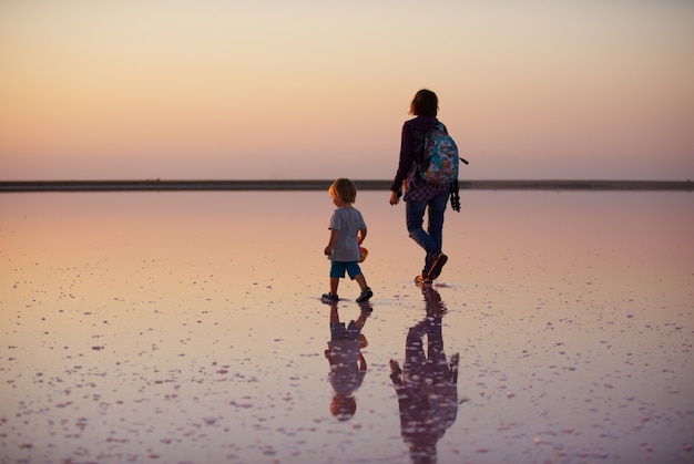 Matka i dziecko chodzi po solance i solance różowy jezioro, na