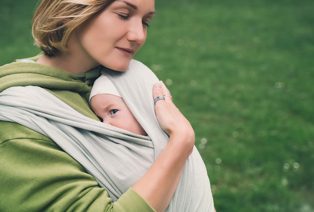 Matka i dziecko na naturze na zewnątrz Dziecko w chuście Kobieta niosąca małe dziecko w chuście