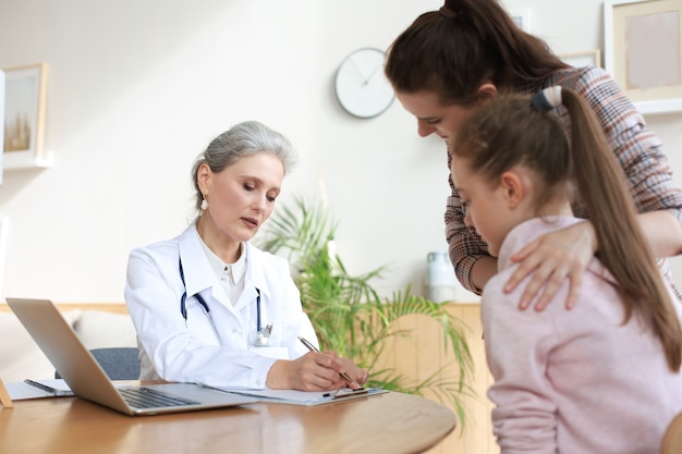 Matka I Dziecko W Gabinecie Lekarskim Spotykają Się Z Pediatrą, Siedzą Przy Biurku W Szpitalu.