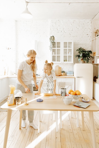 Matka i jej córeczka wspólnie przygotowują ciasto do pieczenia w kuchni w domu.