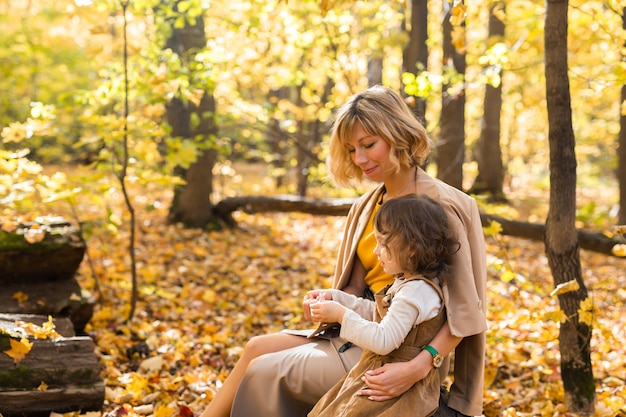 Matka i mała córka cieszą się miłym jesiennym dniem w koncepcji rodziny i dzieci sezon park