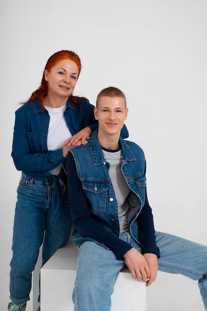 Matka i nastoletni chłopak noszący razem dżinsowe stroje