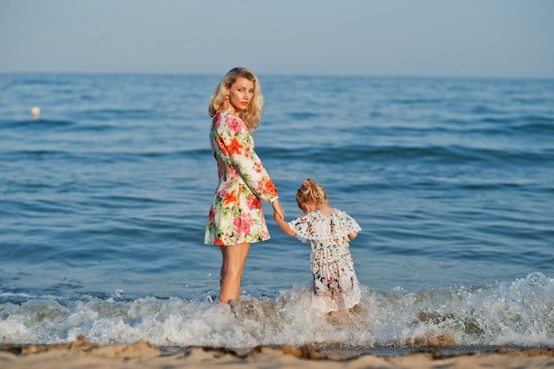 Matka i piękna córka bawią się na plaży Portret szczęśliwej kobiety z uroczą małą dziewczynką na wakacjach