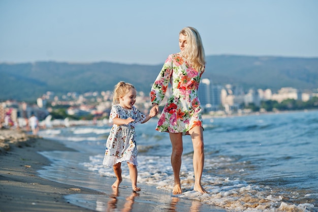 Matka i piękna córka bawią się na plaży Portret szczęśliwej kobiety z uroczą małą dziewczynką na wakacjach