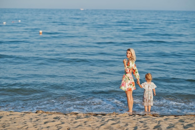 Matka i piękna córka bawią się na plaży Portret szczęśliwej kobiety z uroczą małą dziewczynką na wakacjach