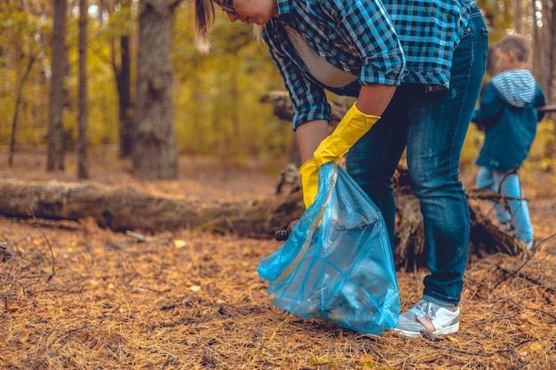 Matka i syn aktywiści ekologiczni zbierają śmieci w lesie Rodzina dba o ratowanie lasów