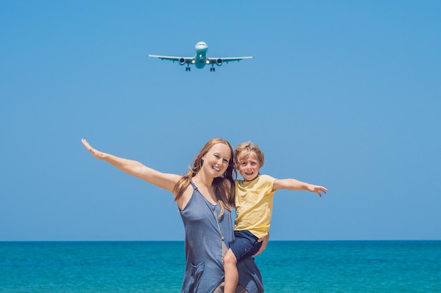 Matka i syn bawią się na plaży, obserwując lądujące samoloty. Podróżowanie samolotem z koncepcją dzieci.
