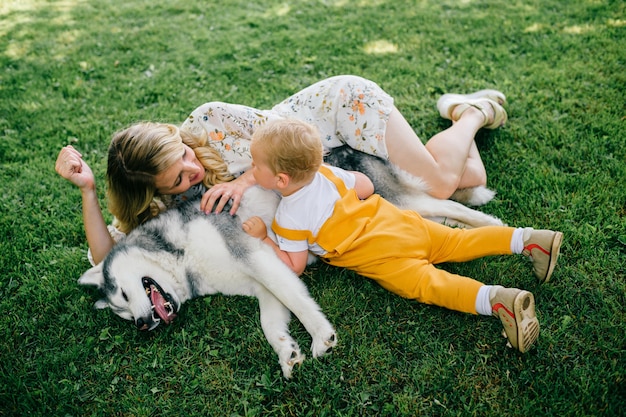 Zdjęcie matka i syn, leżąc z psem na trawie