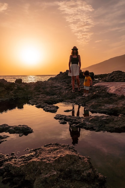 Matka i syn o zachodzie słońca na plaży Tacoron na Wyspach Kanaryjskich El Hierro koncepcja wakacje pomarańczowy zachód słońca