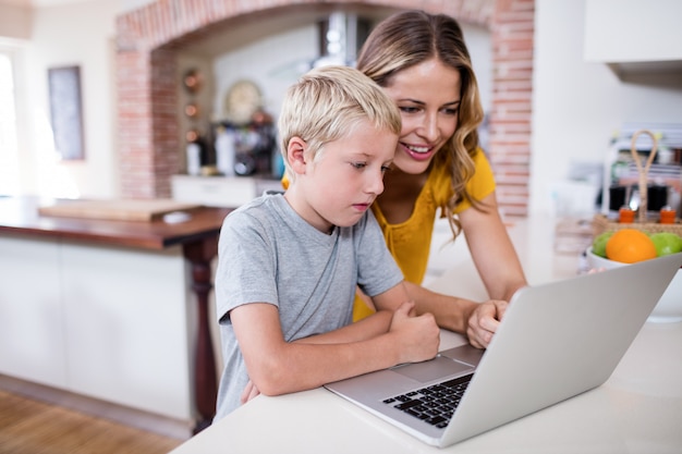 Matka i syn używa laptop w kuchni